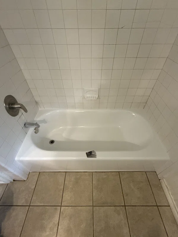 White bathtub and white tiled surround.