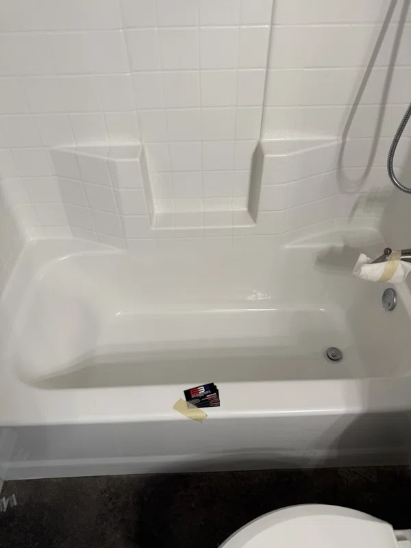 White bathtub and molded surround with shelves and a chrome spout.