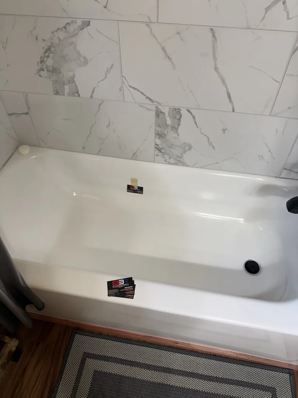 New bathtub with a repaired chip beside marble-pattern tile in Center, Texas.