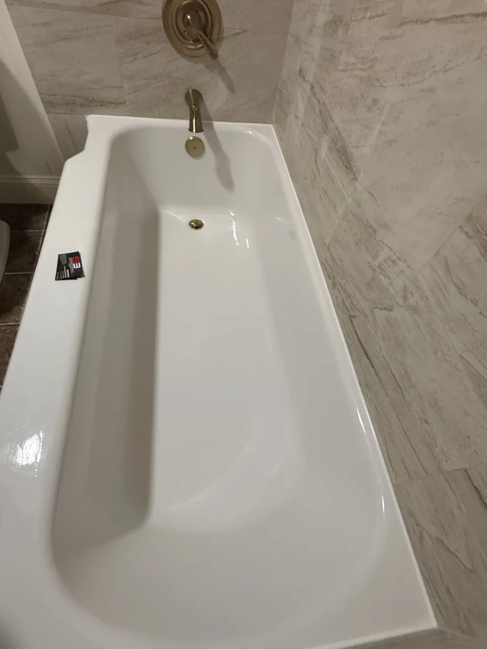 Refinished white cast-iron bathtub with brass fixtures in Longview, Texas.