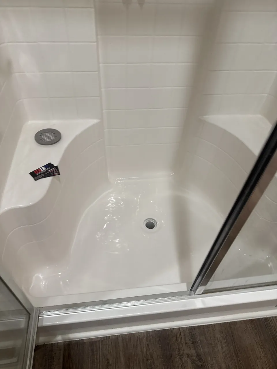 Rebuilt fiberglass shower base with seats and glass enclosure in Gun Barrel City, Texas.