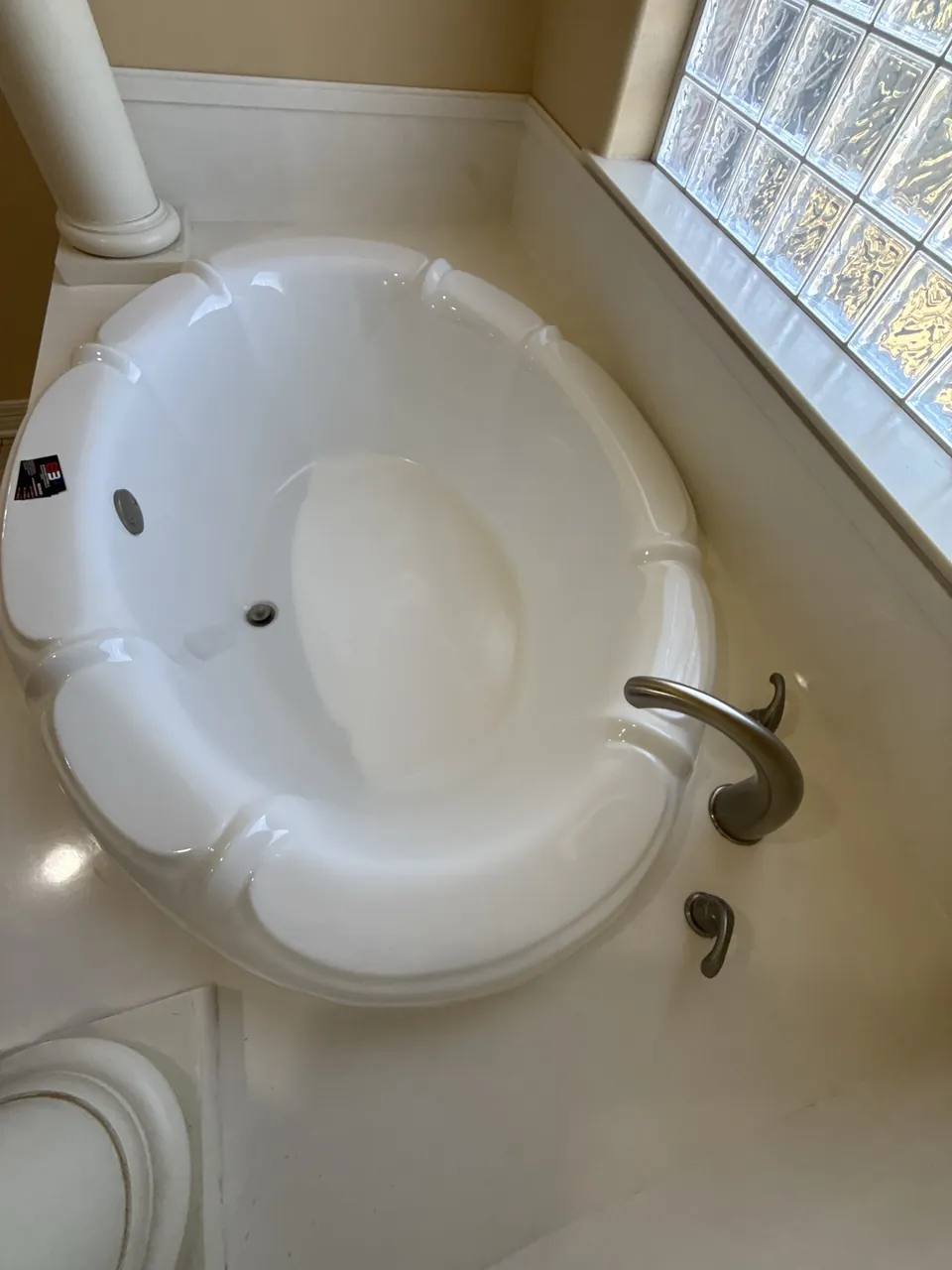 Refinished oversized oval soaking tub with grab handles in Hallsville, Texas.